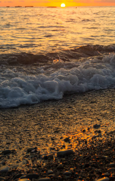 istock Amazing sea sunset on the pebble beach, the sun, waves, clouds 941144908