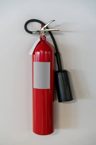 istock Red fire extinguisher hanging against white wall background 941151642