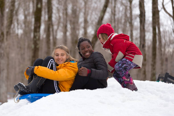 groupe de jeunes filles glissant dans la neige - group of people teenager snow winter photos et images de collection