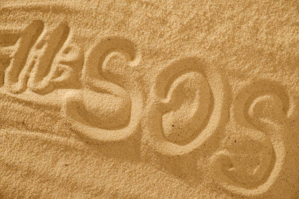 istock Inscription on the sand beach SOS with hashtag. Space for text 941166358