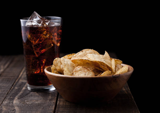 istock Crispy pepper crisps in wooden bowl with cola soda 941175372