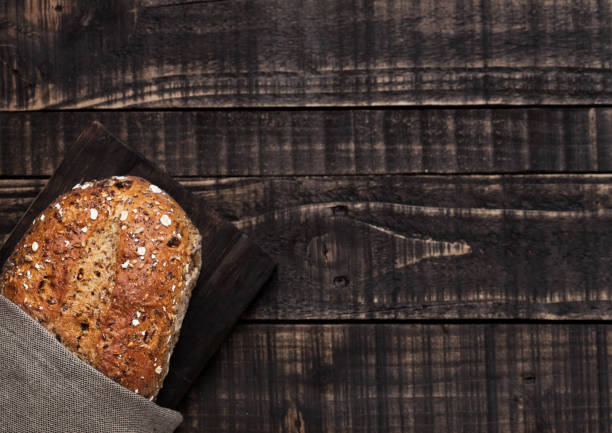 istock Freshly baked  bread with oats on wooden board 941175400
