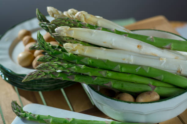 istock Raw uncooked fresh white and green asparagus with small potatoes, ready to cook for dinner 941180986