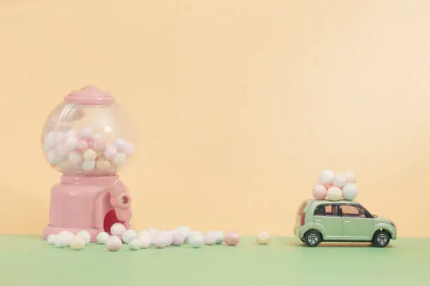 Easter eggs on vintage car with  Egg toy vending machine as background.Selective focus composition and soft pastel color toned for Easter concept background.