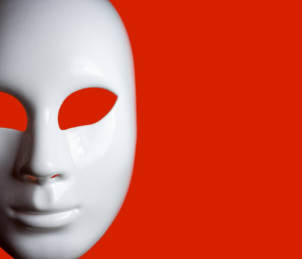 istock White mask of man's face on red background 941187474