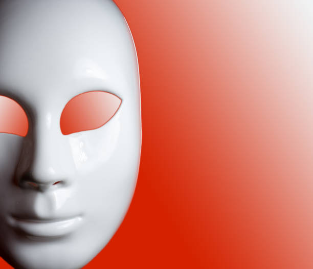istock White mask of man's face on red background 941187514