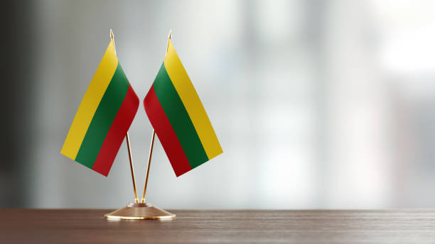 istock Lithuanian Flag Pair On A Desk Over Defocused Background 941190704