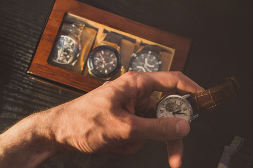 Classic vintage wristwatch with brown leather strap and a wallet and sunglasses