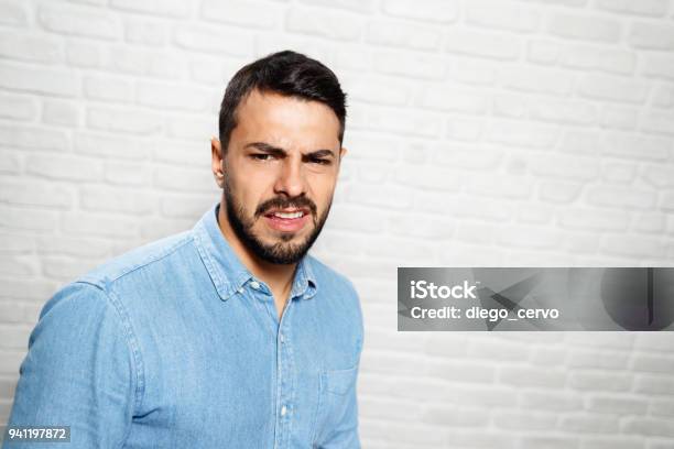 Facial Expressions Of Young Beard Man On Brick Wall Stock Photo - Download Image Now