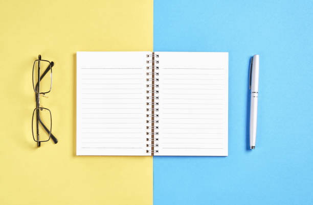 istock Black screen notebook blank and pen placed on pastel yellow and blue background. Suitable for graphics used for advertising. 941202288