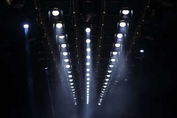 Many Par Led Lights beams Spotlight ray moving lighting on rack construction ceiling, for Fashion Show Event performance in dark room hall for fashion show style decorated floor