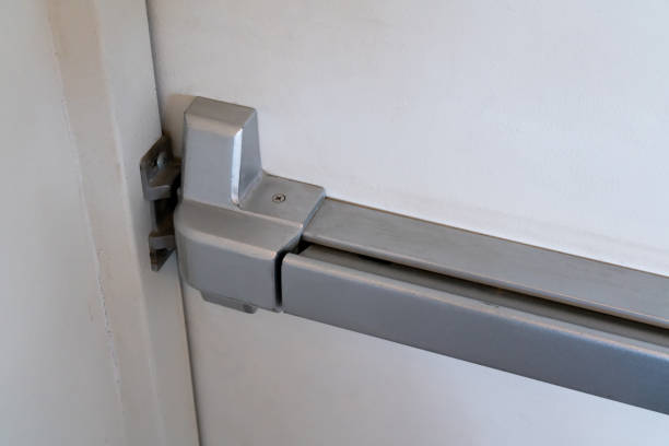 Closed up latch and door handle of emergency exit. Push bar and rail for panic exit. stock photo