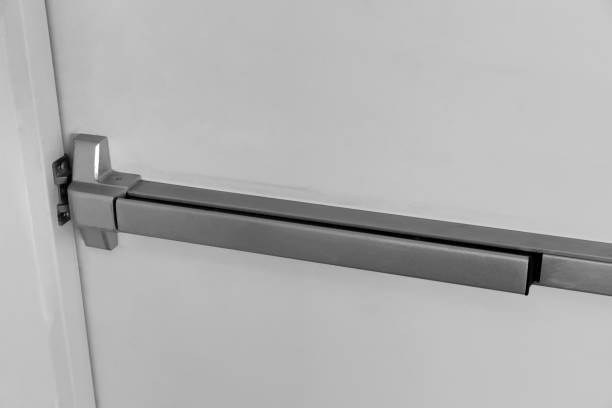 Closed up latch and door handle of emergency exit. Push bar and rail for panic exit.