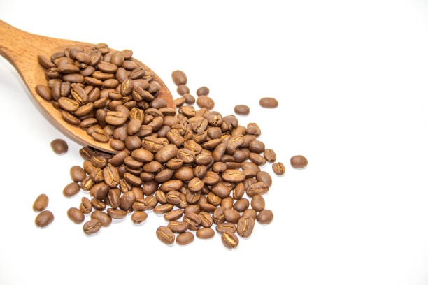 istock Coffee beans in wooden spoon on white background 941212772