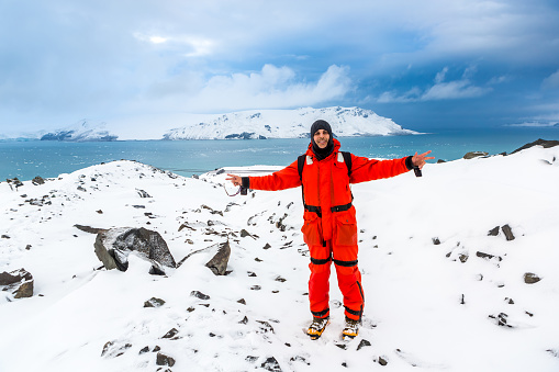 Man walks through ice and snow in Antarctica. Icebergs and everything frozen around you. Cold.