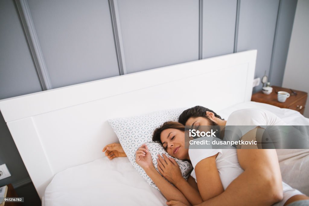 Hermosa Joven Pareja Durmiendo Abrazados En La Cama Foto de stock y más  banco de imágenes de Dormir - iStock