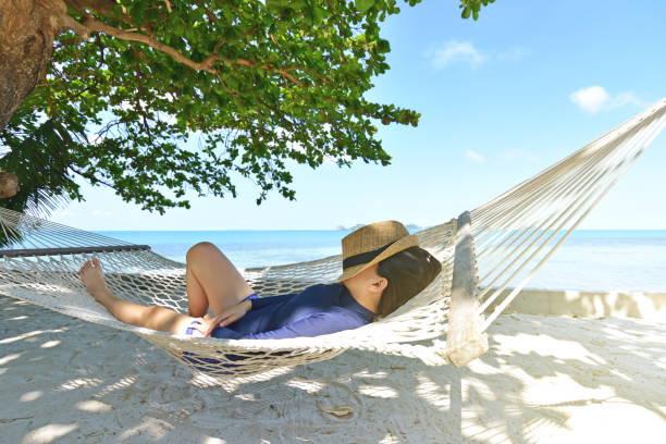istock Happy woman in hammock on tropical paradise beach 941216874