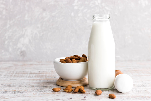 Almonds and almond milk on a light background