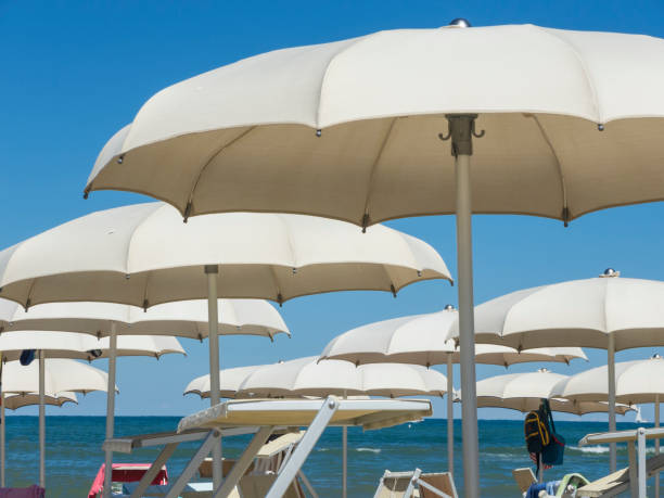 istock Beach umbrellas, gazebos and sun beds at Italian sandy beaches. Adriatic coast. Emilia Romagna region 941229228