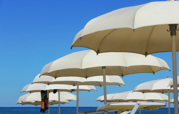 istock Beach umbrellas, gazebos and sun beds at Italian sandy beaches. Adriatic coast. Emilia Romagna region 941229230