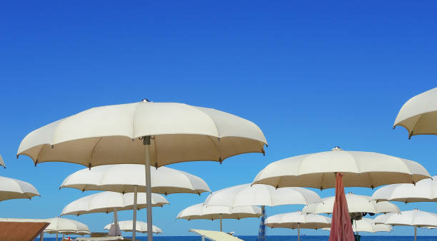 istock Beach umbrellas, gazebos and sun beds at Italian sandy beaches. Adriatic coast. Emilia Romagna region 941229244