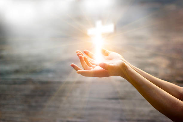 mujer con cruz blanca en las manos pidiendo la bendición de dios en el fondo de la luz del sol, concepto de esperanza - alabar a dios fotografías e imágenes de stock