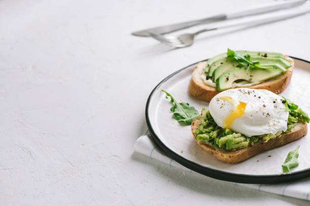 avocado-sandwich mit pochiertem ei - poached stock-fotos und bilder