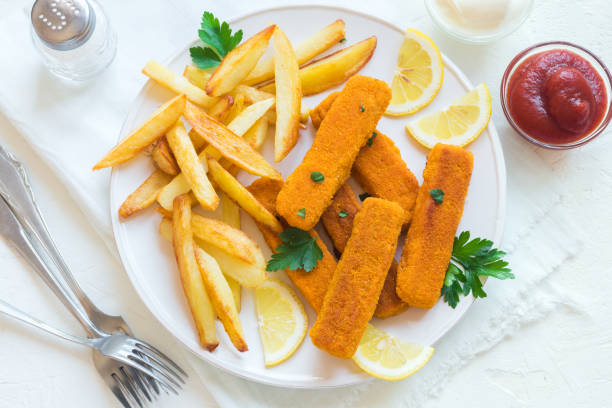 Fried Fish Sticks with French Fries Fried Fish Sticks with French Fries. Fish Fingers. Fish Sticks with fried potato and lemon ready to eat. fish stick stock pictures, royalty-free photos & images