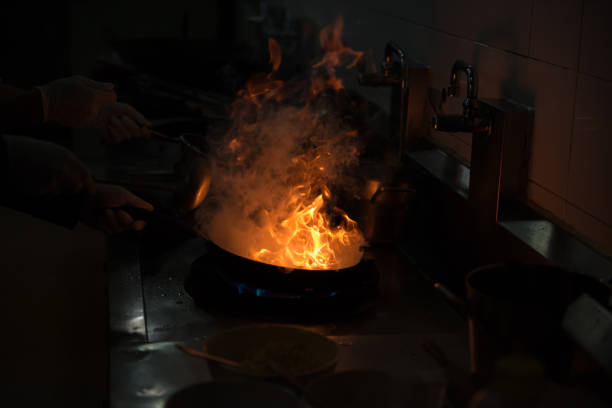 istock Chef cooking and doing flambe on food in restaurant kitchen 941233320
