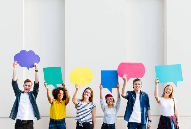 istock Young adult friends holding up copyspace placard thought bubbles 941236652