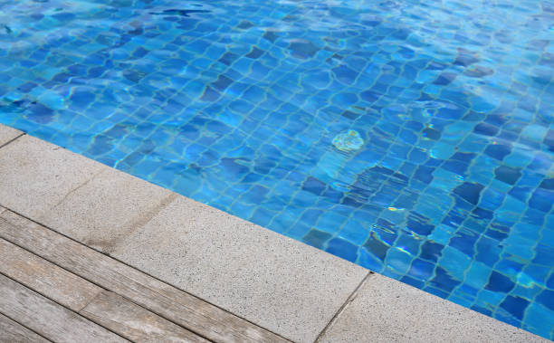 istock Swimming pool with a stone and wooden plank flooring. 941238484