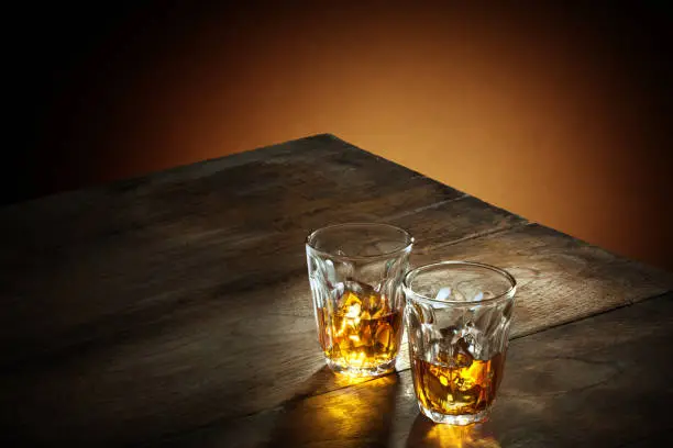 view of two glasses of  whiskey on color background.