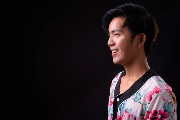 istock Young handsome Asian man against black background 941241412