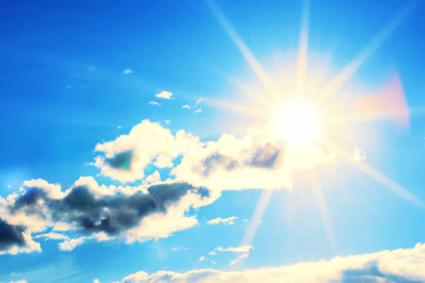 Bright sun with beautiful beams in the blue sky with clouds. Space for copy, high resolution - 50 megapixels.