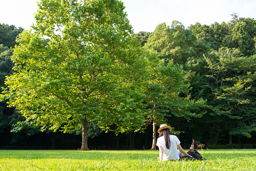 Japanese women relax in the park with Doberman