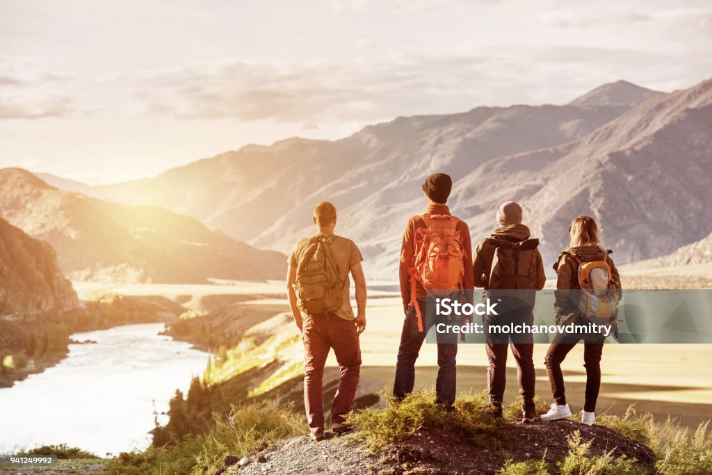 Montañas al atardecer cuatro amigos viajan concepto - Foto de stock de Grupo de personas libre de derechos