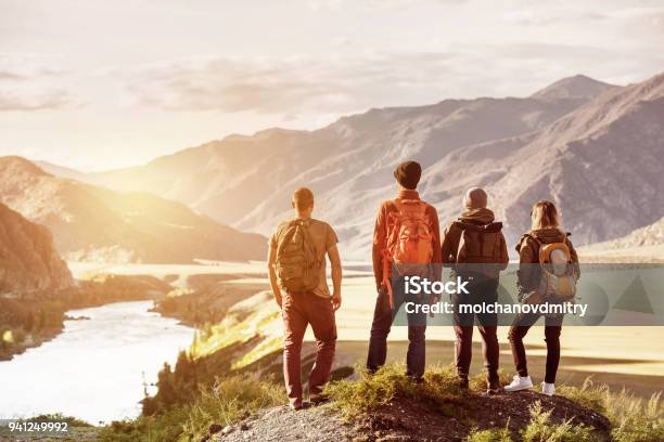 Montañas Al Atardecer Cuatro Amigos Viajan Concepto Foto de stock y más banco de imágenes de Grupo de personas