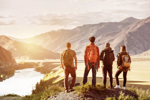 Four friends sunset mountains travel concept Four friends stands on view point and looking at sunset mountains and river. Adventures travel concept with space for text altai nature reserve photos stock pictures, royalty-free photos & images