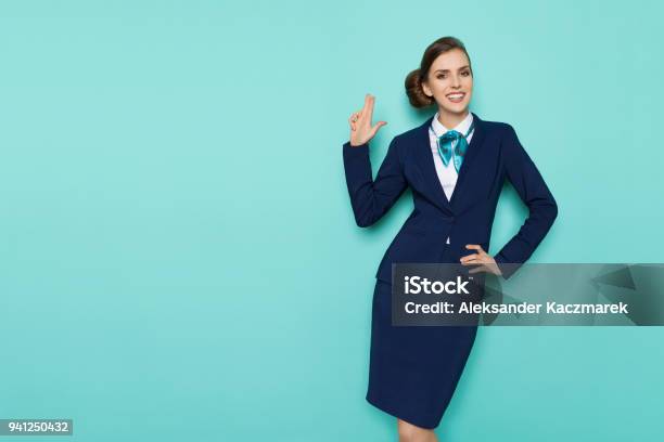 Smiling Stewardess Is Showing Pistol Hand Sign Stock Photo - Download Image Now - Air Stewardess, Cabin Crew, Commercial Airplane