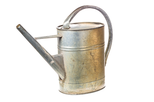 Old vintage metal watering can isolated on white background