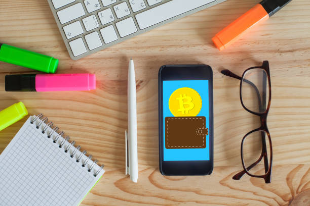istock Top view office workplace with keyboard, markers and smartphone. Bitcoin cryptocurrency payment application. 941258132