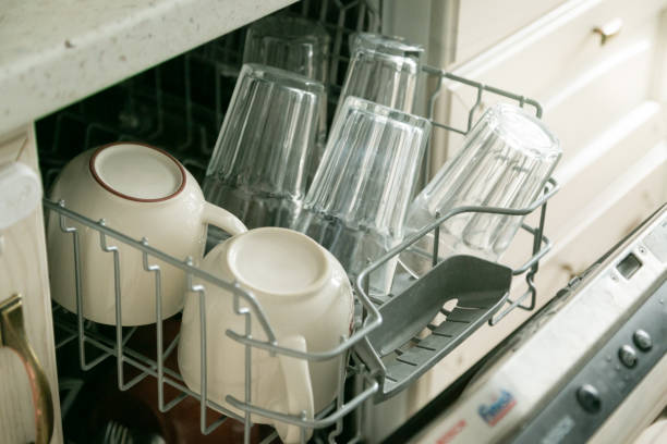 istock Dishwasher full with clean dishes in kitchen background 941260062