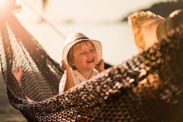 istock Happy boy talking to his parent in a hammock at the beach. 941260230