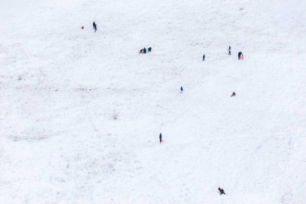 Kids playing with toboggans on a big hill after a big Colorado snow storm.