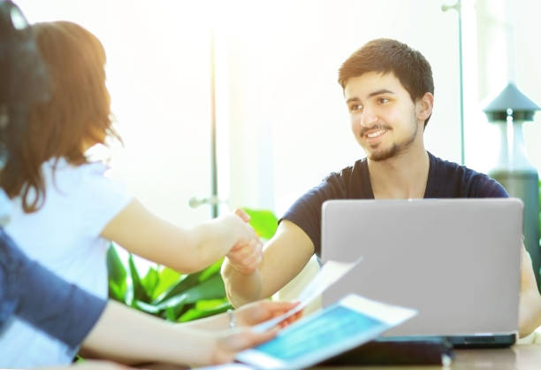 istock close up.Manager shaking hands with client sitting at his Desk 941268656