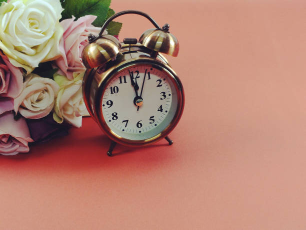 istock alarm clock and artificial flowers bouquet with filter color 941272386