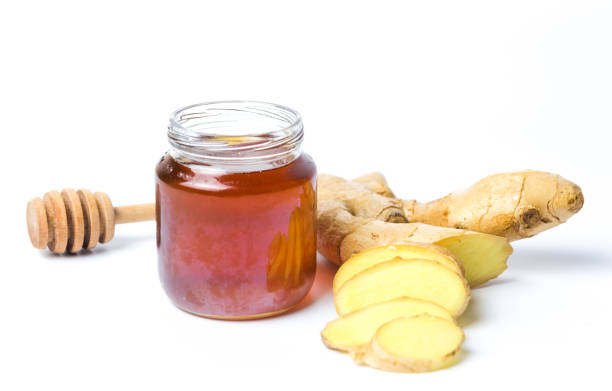 istock Jar of honey and gingers isolated on white background 941275950