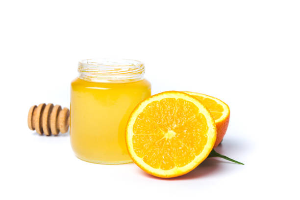 istock Jar of honey and orange isolated on white background 941276056
