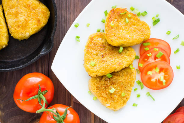 istock Crispy hash browns and tomatoes on a plate on a wooden table 941276540