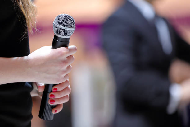 istock Woman stands on stage with microphone durring speech 941278358
